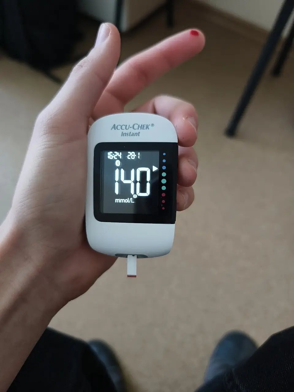 Клієнт тримає глюкометр Accu-Chek Instant під час вимірювання